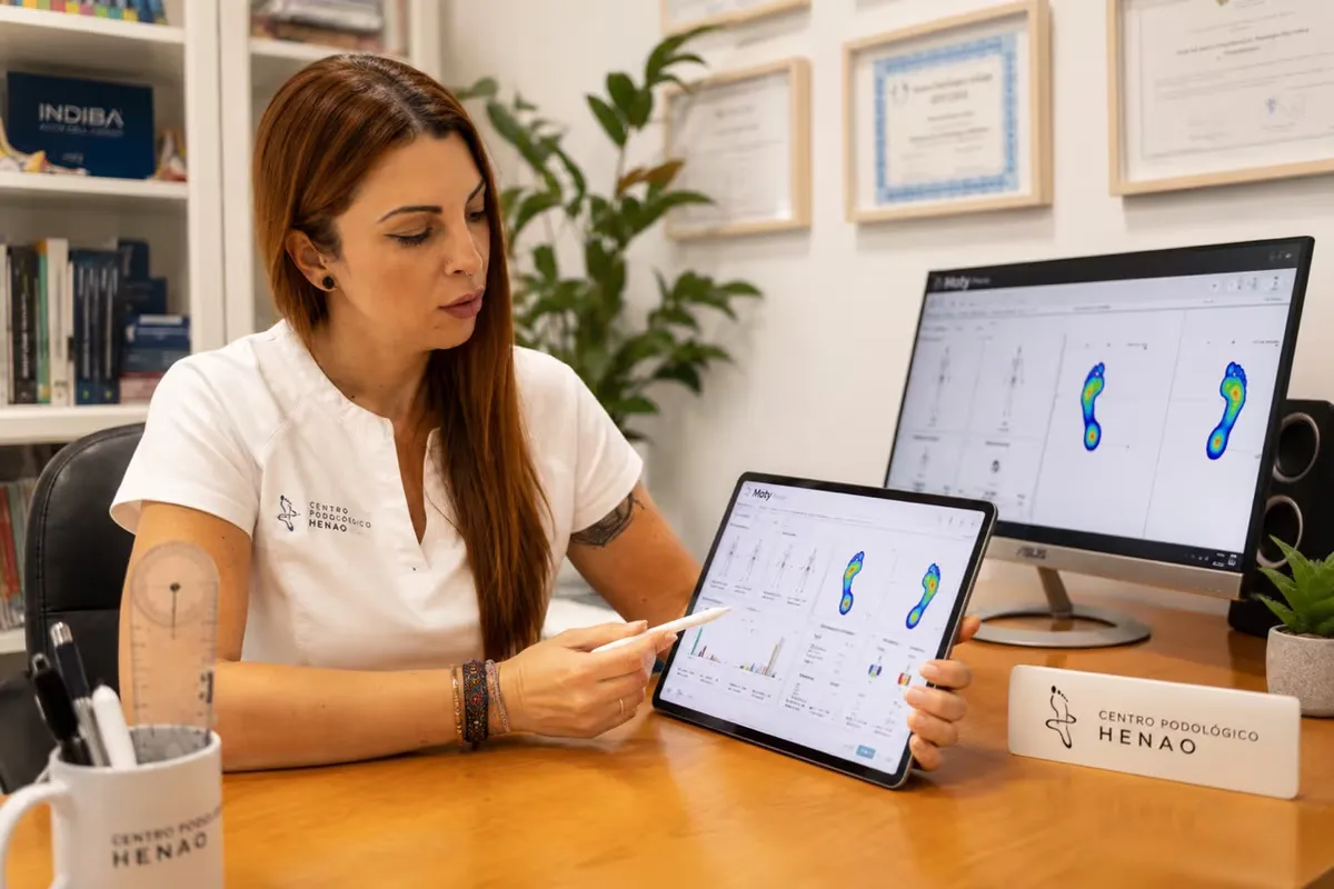 La Dra. Gisela Gómez analizando un estudio de la pisada en una tableta y un monitor en la consulta de CPH