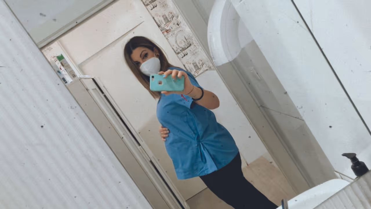 La Dra. Gisela Gómez López, podóloga y directora de Centro Podológico Henao, embarazada y con uniforme clínico en la consulta de Bilbao